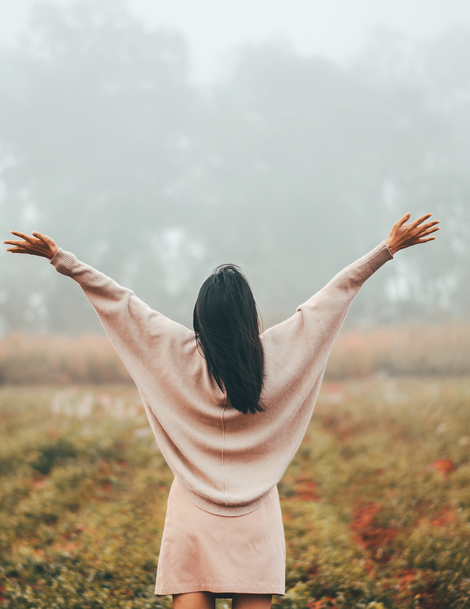 Woman raising arms in a field